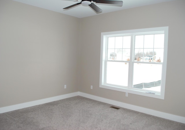 spare room with ceiling fan and light carpet