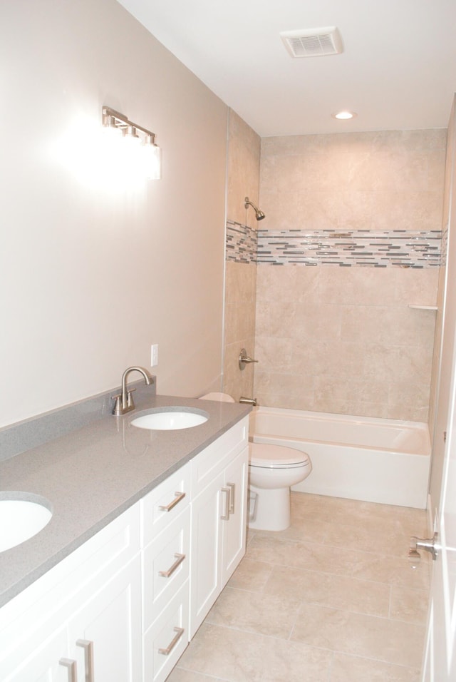 full bathroom featuring toilet, vanity, tiled shower / bath combo, and tile patterned floors