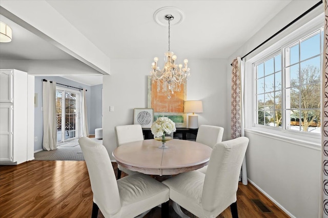 dining room featuring an inviting chandelier, plenty of natural light, and dark hardwood / wood-style flooring