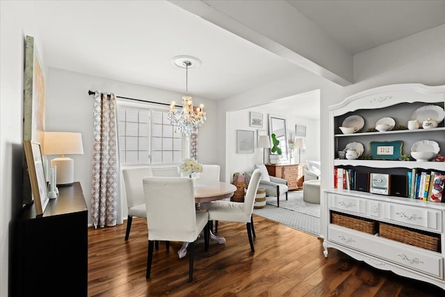 dining space with dark wood-type flooring and an inviting chandelier