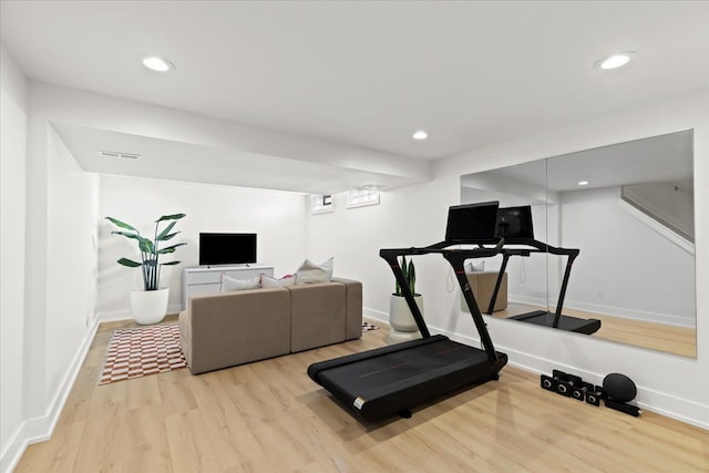 exercise room with light hardwood / wood-style floors