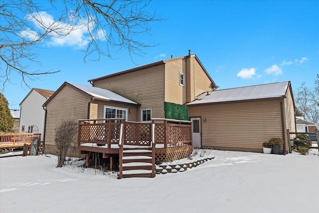 snow covered property with a deck