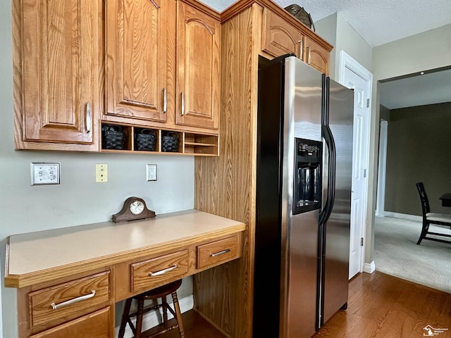 kitchen with dark wood-type flooring, a textured ceiling, and stainless steel refrigerator with ice dispenser