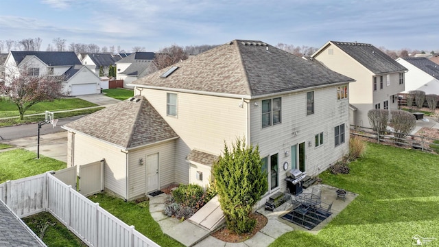 rear view of house with a patio and a lawn