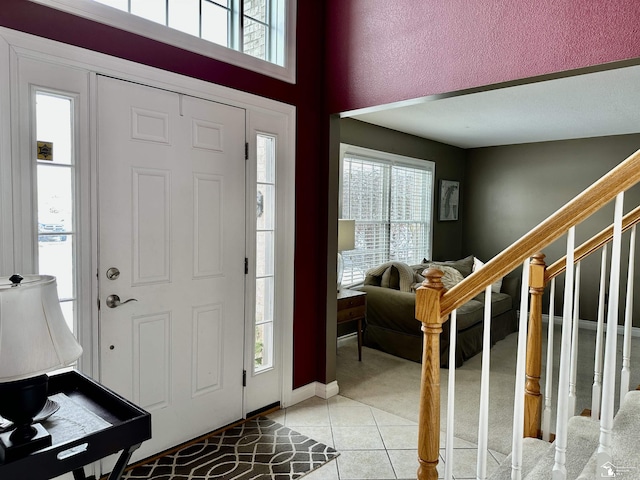 foyer entrance featuring a wealth of natural light and light tile patterned floors