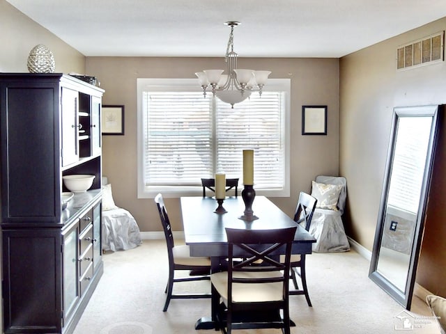 dining space featuring light carpet, a chandelier, and a healthy amount of sunlight