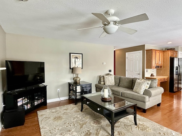 living room with wood-type flooring, a textured ceiling, and ceiling fan