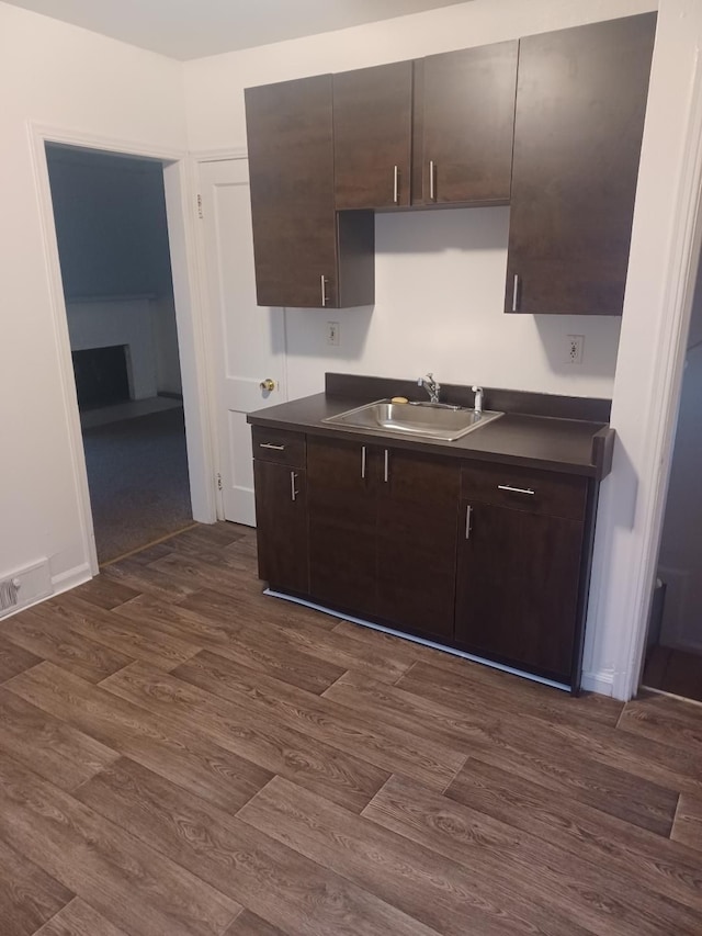 kitchen featuring sink, dark hardwood / wood-style floors, and dark brown cabinets