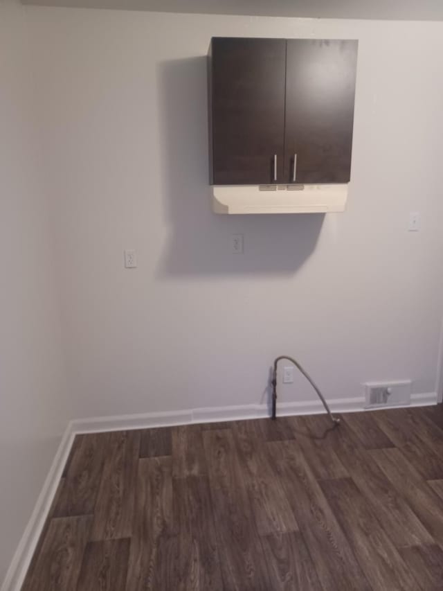 washroom featuring dark wood-type flooring and cabinets