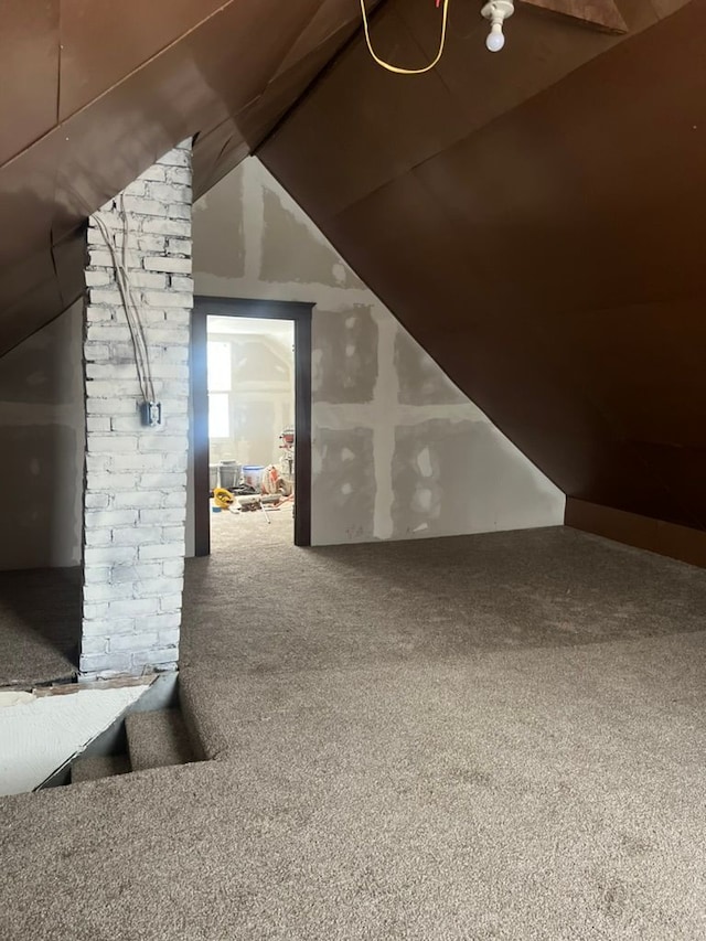 additional living space featuring lofted ceiling and carpet flooring