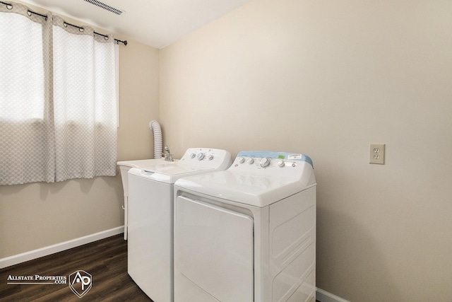 laundry area with separate washer and dryer and dark wood-type flooring