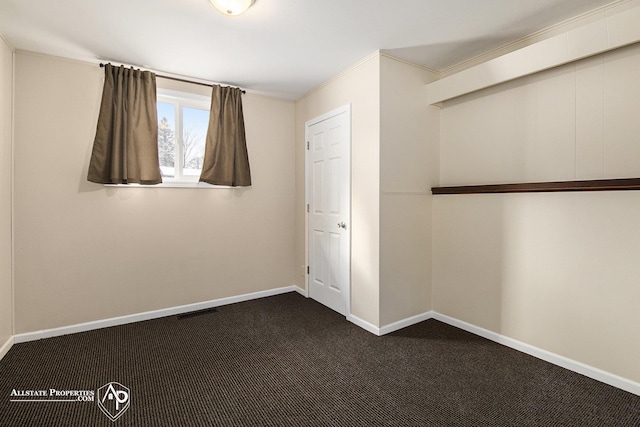 unfurnished bedroom featuring dark carpet and ornamental molding