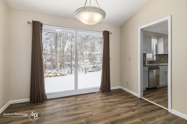 unfurnished dining area with dark wood-type flooring, vaulted ceiling, and sink