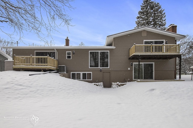 snow covered house featuring central AC, a deck, and a balcony