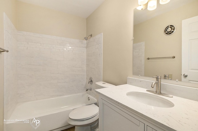 full bathroom featuring vanity, tiled shower / bath combo, and toilet