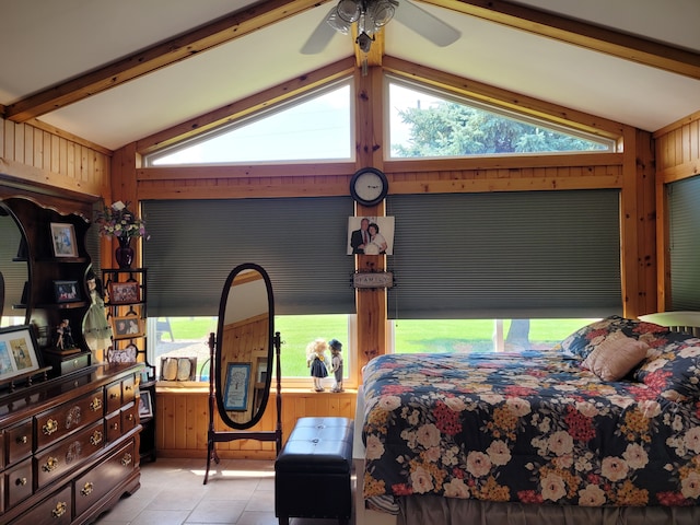 tiled bedroom with ceiling fan, wood walls, and vaulted ceiling