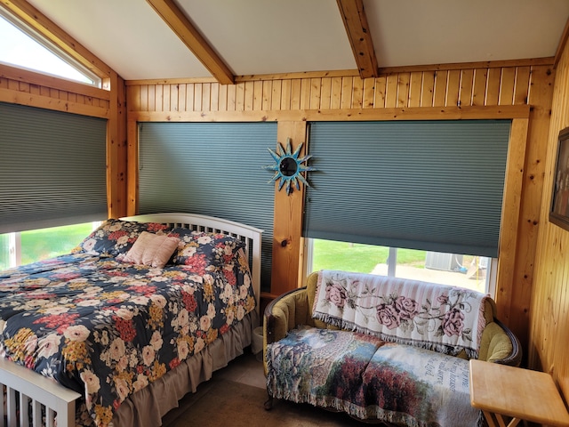 carpeted bedroom featuring multiple windows, lofted ceiling with beams, and wooden walls