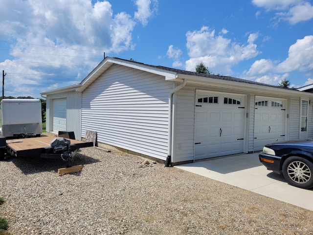 view of side of home featuring a garage and an outbuilding