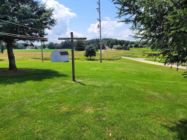 view of property's community with a lawn and a storage unit