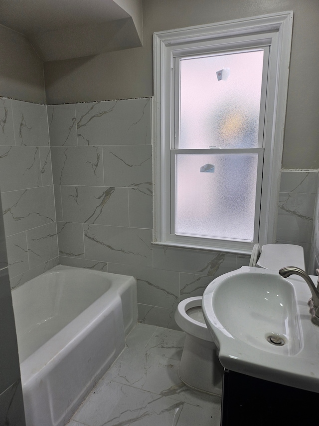 bathroom with tile walls, vanity, and plenty of natural light