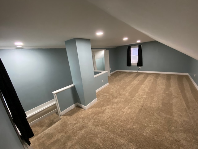 additional living space with light colored carpet and lofted ceiling