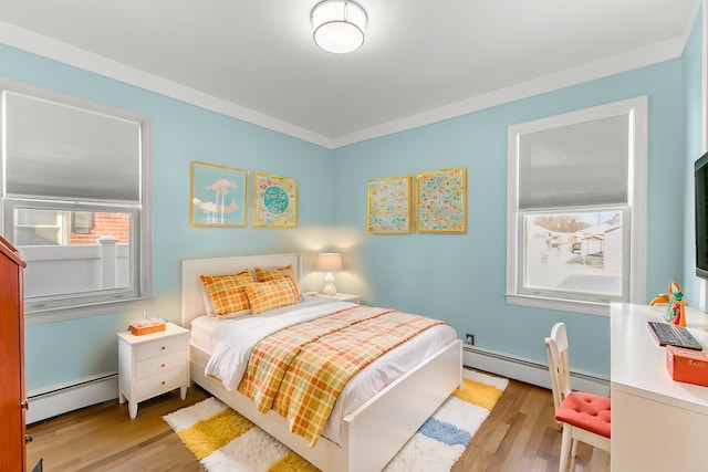 bedroom featuring ornamental molding, light hardwood / wood-style flooring, and a baseboard radiator