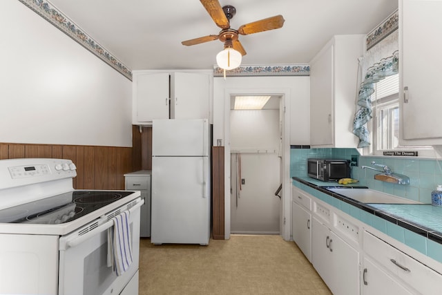 kitchen with ceiling fan, white cabinetry, sink, and white appliances