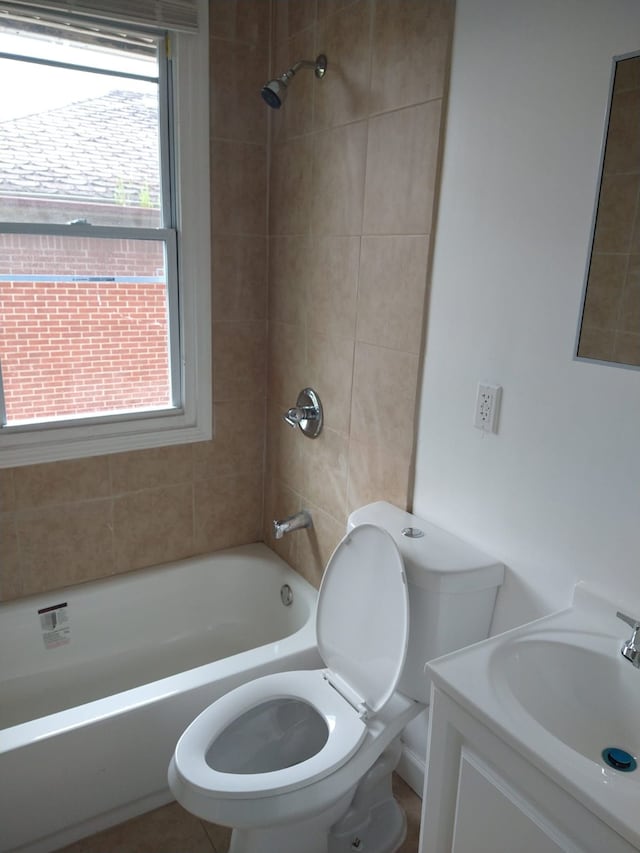 full bathroom featuring vanity, a wealth of natural light, tiled shower / bath combo, and toilet