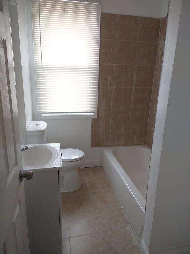 full bathroom featuring toilet, vanity, tile patterned floors, and tiled shower / bath combo