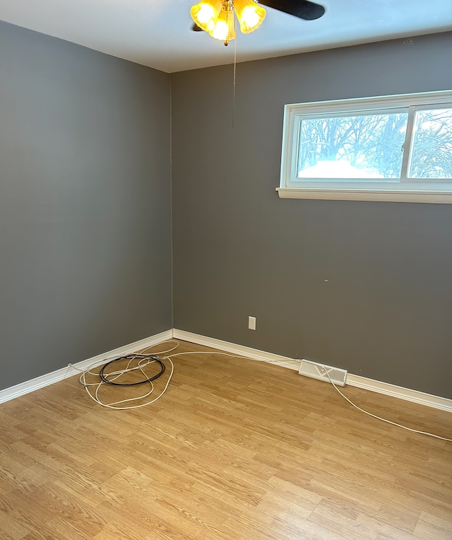 empty room with ceiling fan and light hardwood / wood-style floors