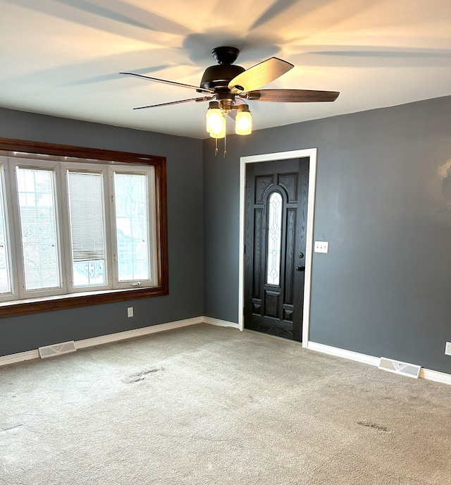 empty room featuring carpet flooring and ceiling fan