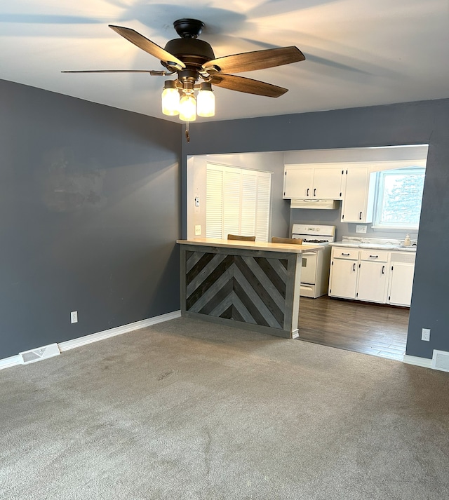 carpeted living room with ceiling fan