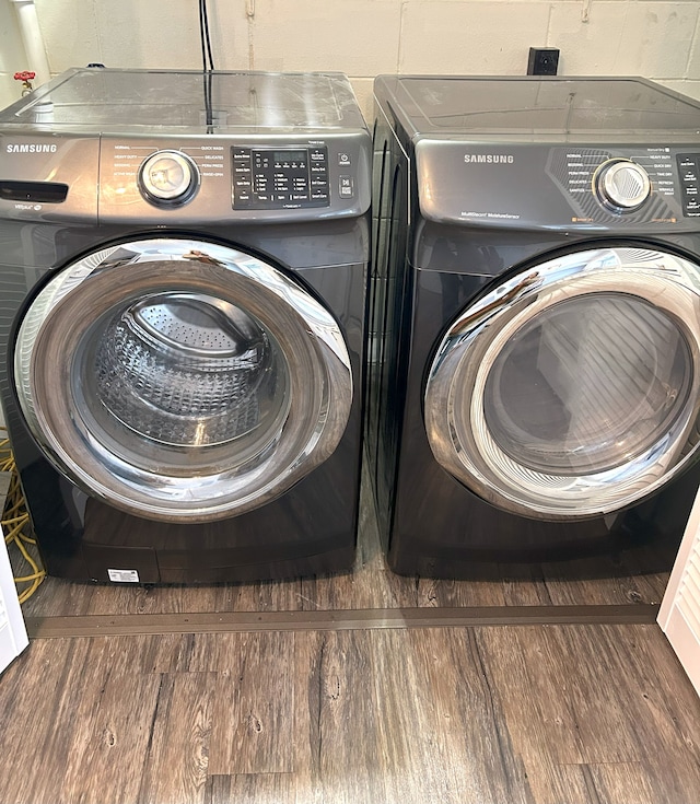 laundry area with separate washer and dryer and dark hardwood / wood-style flooring