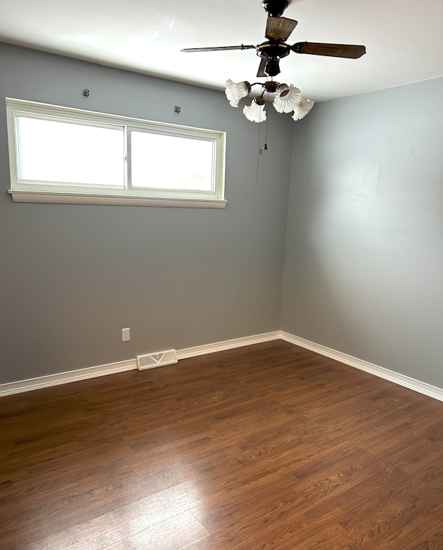 unfurnished room featuring ceiling fan and dark wood-type flooring