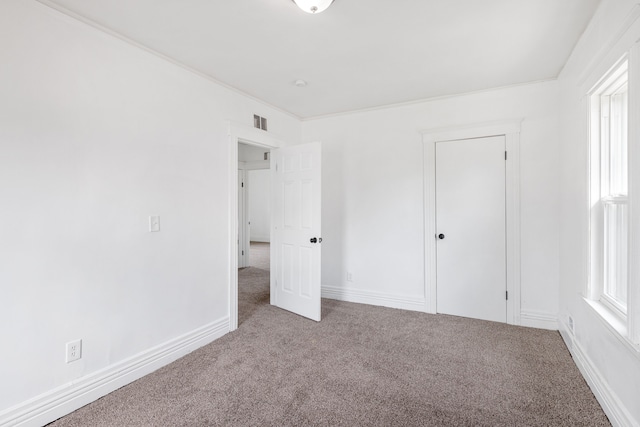 unfurnished bedroom featuring carpet and crown molding