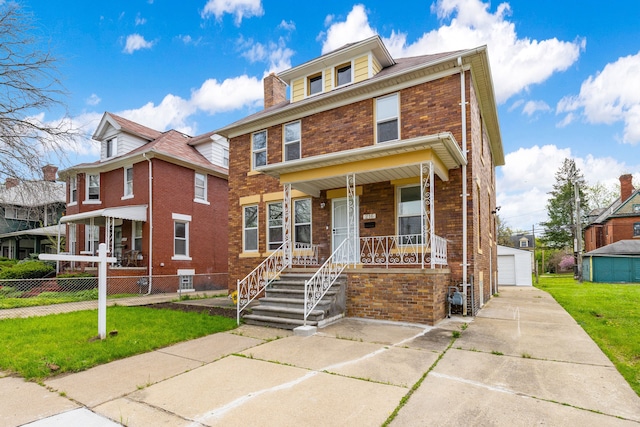 townhome / multi-family property with an outbuilding, a front lawn, covered porch, and a garage