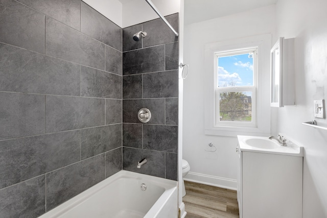 full bathroom with toilet, tiled shower / bath, wood-type flooring, and vanity