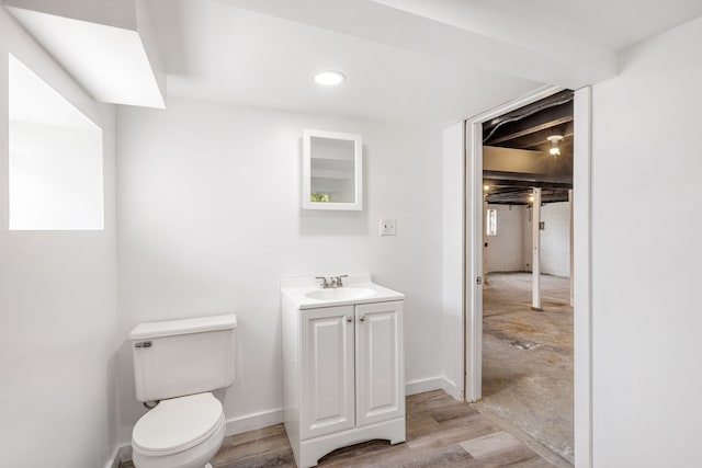 bathroom featuring hardwood / wood-style flooring, toilet, and vanity