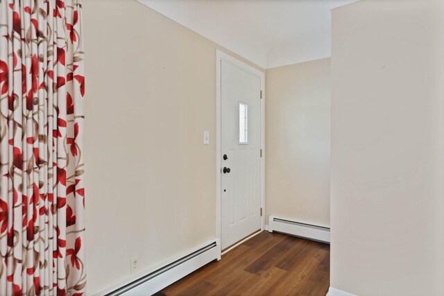 foyer entrance featuring baseboard heating and dark hardwood / wood-style floors