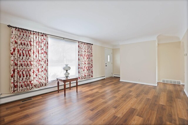 unfurnished room featuring hardwood / wood-style floors and a baseboard radiator