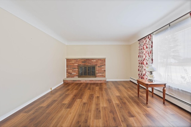 9800 Gera Rd, Birch Run, MI 48415 - unfurnished living room with wood finished floors, a brick fireplace, baseboards, and a baseboard radiator