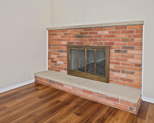 9800 Gera Rd, Birch Run, MI 48415 - detailed view of baseboards, a brick fireplace, and wood finished floors
