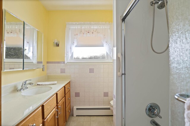 bathroom featuring tile walls, toilet, vanity, and a baseboard heating unit