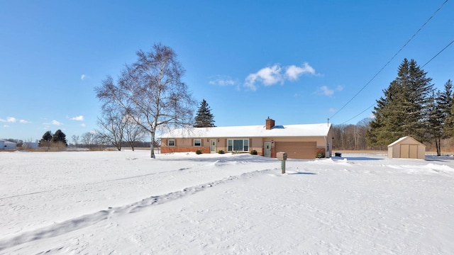 snow covered property with a shed