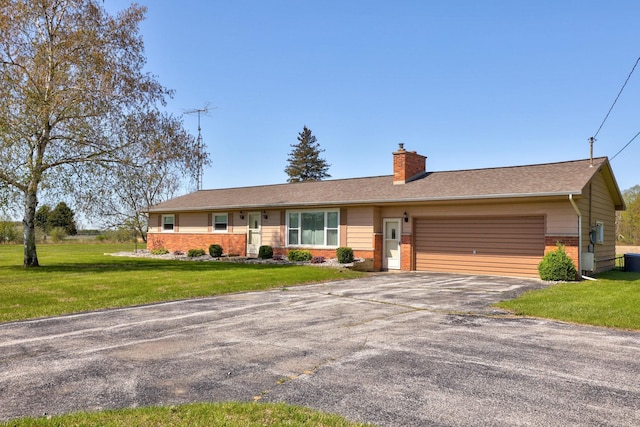 9800 Gera Rd, Birch Run, MI 48415 - single story home featuring brick siding, asphalt driveway, an attached garage, a chimney, and a front lawn