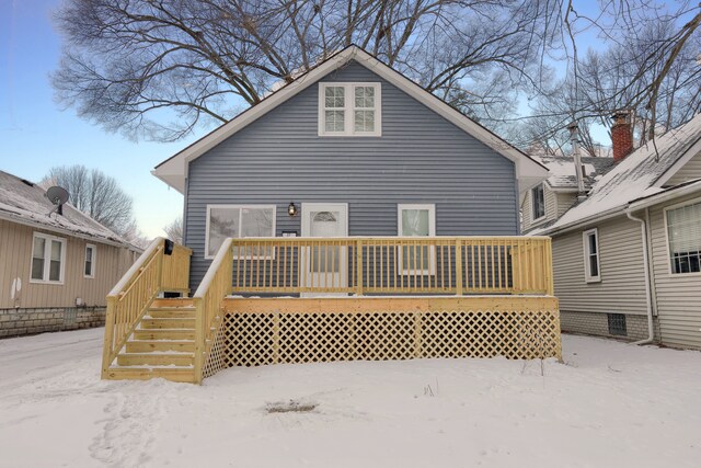 snow covered house featuring a wooden deck