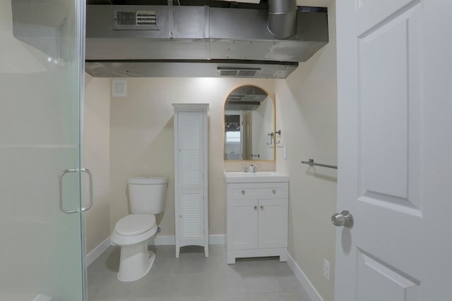 bathroom with vanity, tile patterned flooring, toilet, and walk in shower