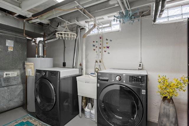 laundry room with water heater, a healthy amount of sunlight, and separate washer and dryer