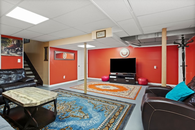 living room with a paneled ceiling and concrete floors