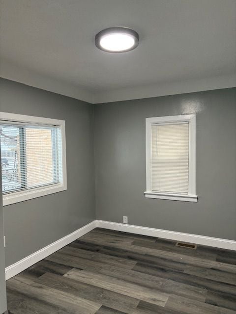 spare room with dark hardwood / wood-style flooring